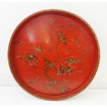 A large late 19th / early 20th century circular red lacquerware gilded tray decorated with birds
