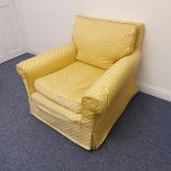 A good quality club-style upholstered armchair on short stained wooden legs with brass castors,