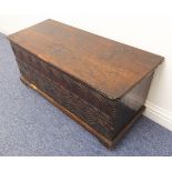 A 17th or 18th century oak chest of boarded construction: the well-patinated hinged top engraved