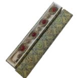 A Chinese white metal bracelet: four mounted Carnelian-style stones polished en cabochon separated