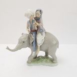 A Lladro porcelain model of two Hindu children riding upon the back of a elephant calf: impressed