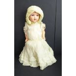 A mid-20th century blue sleeping-eyes doll in a light-yellow bonnet and similar dress, the back of