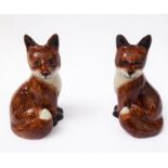 An unusual ceramic cruet set modelled as two opposing foxes sejant (salt and pepper)