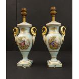 A pair of porcelain table lamps in Paris style; each with two gilded handles and painted vignettes