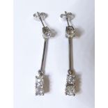 A pair of 18-carat white gold and diamond earrings; the dropper style each consisting of three old-