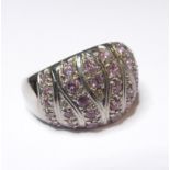 A silver dress ring diagonally set with small hand-cut pink stones, ring size M