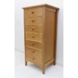 A modern seven-drawer oak chest of slim proportions (56.5 cm wide x 49.5 cm deep x 124.5 cm high)