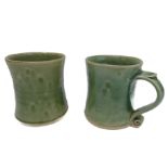 Jeremy Leach -  a pair of celadon-type glazed pottery mugs of waisted form with ribbed scroll