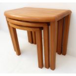 A nest of three modern design-style bow-fronted teak occasional tables