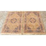 A pair of 20th century Belgian machine-made cotton rugs: each with burnt amber ground and central