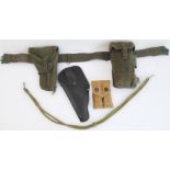 Three items of British Army equipment: a green canvas webbing comprising belt, holster and pouch;