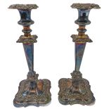 A pair of large silver-plate on copper candlesticks. (One broken where the stem meets the base,