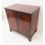 A reproduction mahogany two-door cabinet: moulded top above flame-mahogany and veneered front,