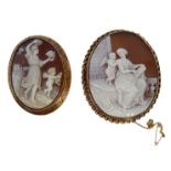 Two oval shell cameo brooches: the first depicting a seated lady reading to Cupid within a collet