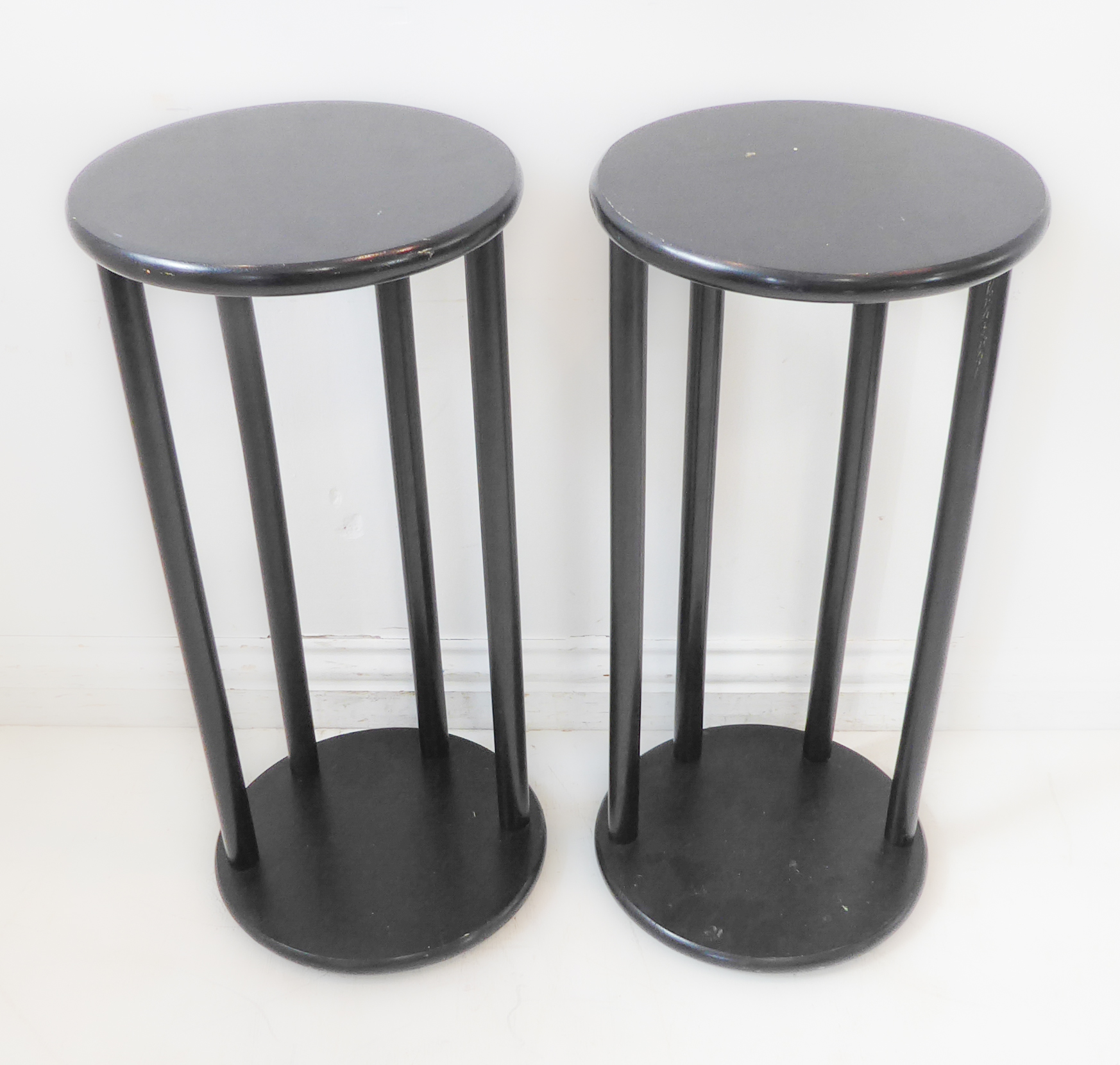 A pair of circular ebonised wooden stands (30cm diameter x 65cm high)