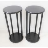 A pair of circular ebonised wooden stands (30cm diameter x 65cm high)