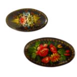 Two Russian oval papier-mâché brooches: hand-decorated with enamels with floral sprays