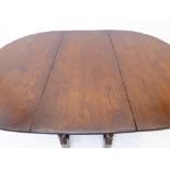 A large oval dropleaf gateleg dining table on baluster-turned supports and single end drawer (