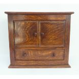 An early 20th century (hanging or table) oak cabinet: the slightly overhanging top above two