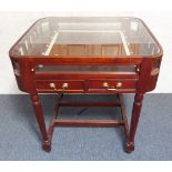 An unusual glass-topped bijouterie table: two half-width front frieze drawers below a pull-out