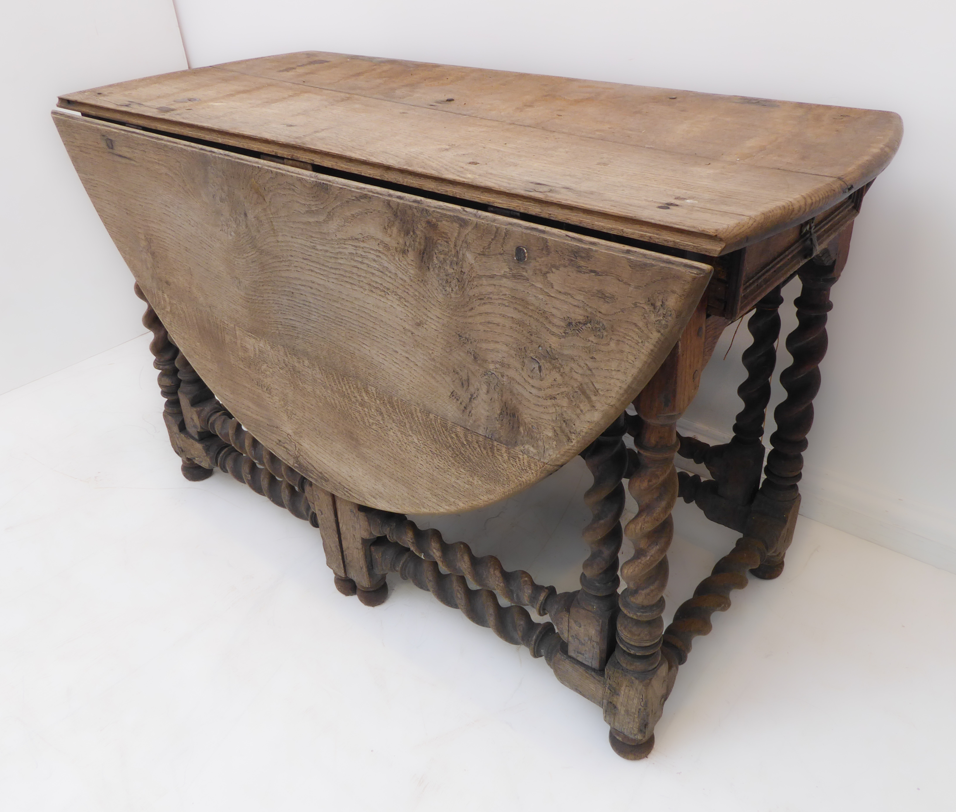 A large oval-topped double-gateleg drop-leaf table with single end-drawer; probably late 17th or