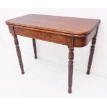 An early 19th century foldover top, mahogany tea table: the figured strung top above a pain frieze