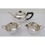 A hallmarked silver three-piece tea-service comprising teapot, milk jug and two-handled sugar. The