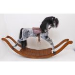 A large and fine hand-carved dapple-grey rocking horse: black mane, embossed leather saddle and