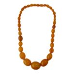 20th century string of 36 graduated butterscotch amber beads, Weight 104g (approx).Main bead with