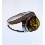 A silver dress ring set with amber polished en cabochon, ring size R