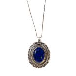 An oval, silver pendant and chain: the pendant set with central blue polished stone