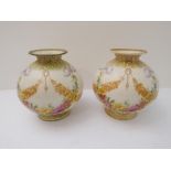 A pair of Edwardian ceramic vases of ovoid form: short flaring necks and decorated in enamels with