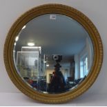 An early to mid 20th century circular gilt-framed wall-hanging looking glass with shallow hand-