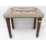 A modern stool: floral needlework gros point stitched upholstery above four turned, tapering stained