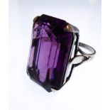 A lady's silver dress ring set with a large, emerald-cut, amethyst-style stone (the table