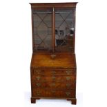 An 18th century mahogany bureau bookcase: the associated top with two thirteen panel astragal glazed