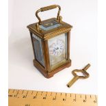 A miniature brass carriage clock with key