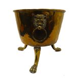 A late 19th century brass coal-bucket of cauldron form: two mask-and-ring handles, raised on three