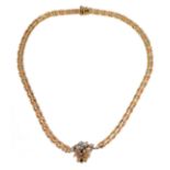 A 14-carat yellow gold (marked '585', Italy) openwork neck chain with an integral flowerhead style