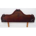 A large 19th century figured mahogany bed headboard carved with leaves and foliate style scrolls (