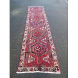 RED GROUND PERSIAN HERIZ RUNNER FROM NORTHERN IRAN WITH TRADITIONAL MEDALLION DESIGN,