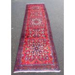 RICH RED GROUND IRANIAN RUNNER WITH FLORAL MEDALLION DESIGN,