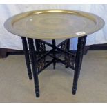 ORIENTAL CIRCULAR BRASS TRAY TOPPED TABLE WITH DECORATIVE CARVING ON TURNED EBONISED STAND,