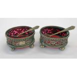 PAIR OF SILVER SALTS WITH PIERCED DECORATION ON BUN FEET AND CRANBERRY GLASS LINERS,