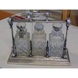 SILVER PLATED GRINSELLS PATENT 3 DECANTER TANTALUS WITH FLORAL & BIRD CHASED DECORATION.