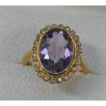 18CT GOLD AMETHYST & DIAMOND CLUSTER RING, THE OVAL AMETHYST APPROX. 4.