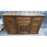 LATE 19TH CENTURY OAK DRESSER WITH DECORATIVE CARVING AND 2 CENTRAL DRAWERS OVER PANEL DOOR FLANKED