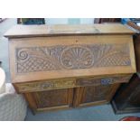 LATE 19TH CENTURY CARVED OAK BUREAU WITH FALL FRONT OVER 2 FRIEZE DRAWERS OVER 2 PANEL DOORS,