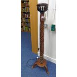 ARTS & CRAFTS STYLE MAHOGANY STANDARD LAMP WITH DECORATIVE CARVING ON 3 SPREADING SUPPORTS,