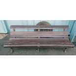 WOODEN GARDEN BENCH ON CAST METAL SUPPORTS,